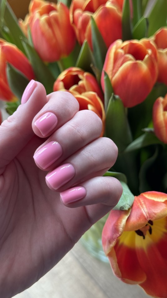 Różowy manicure na tle tulipanów